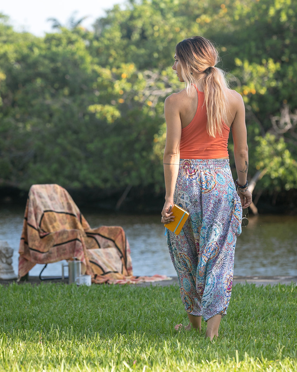 woman in purple pants walking with dog near a stream #color_purple galactic