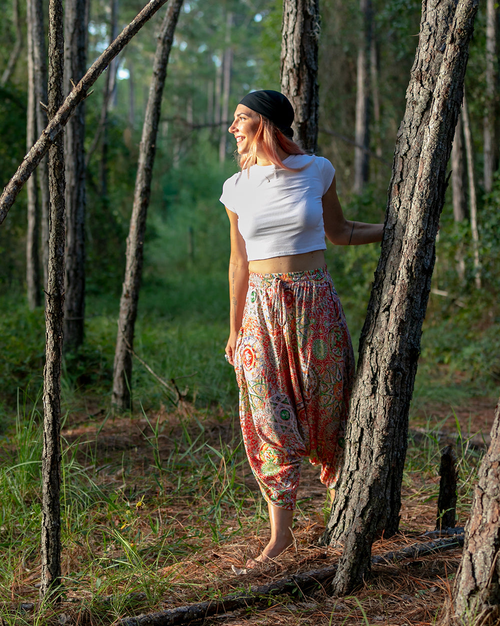Woman posing in forest wearing red galactic MC Hammer pants #color_Red Galactic