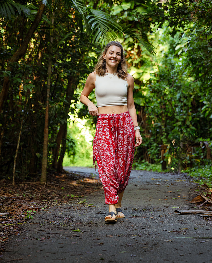 Red lotus harem pants worn while walking through a wooded path #color_red lotus