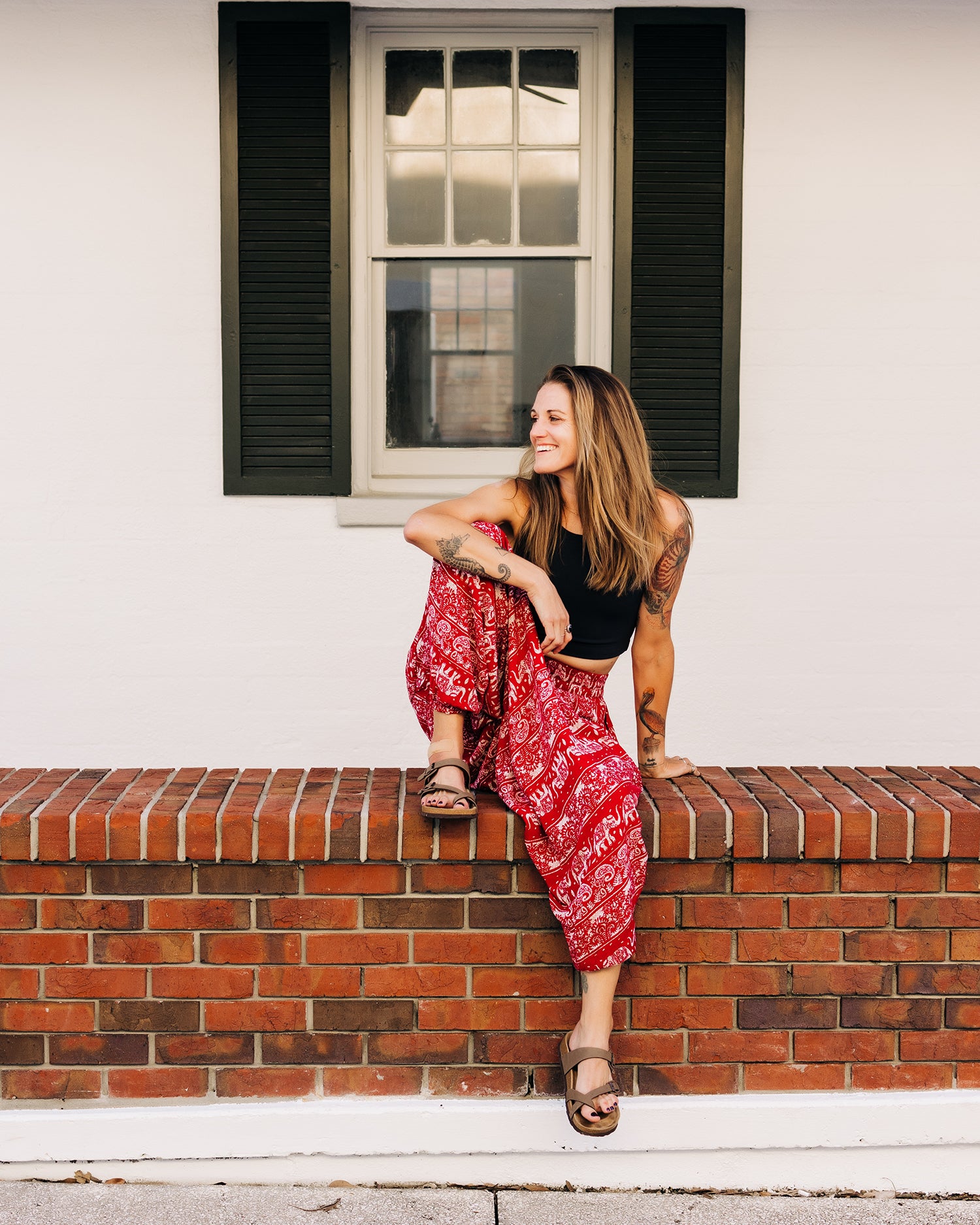 woman wearing loose harem pants while relaxing #color_red lotus