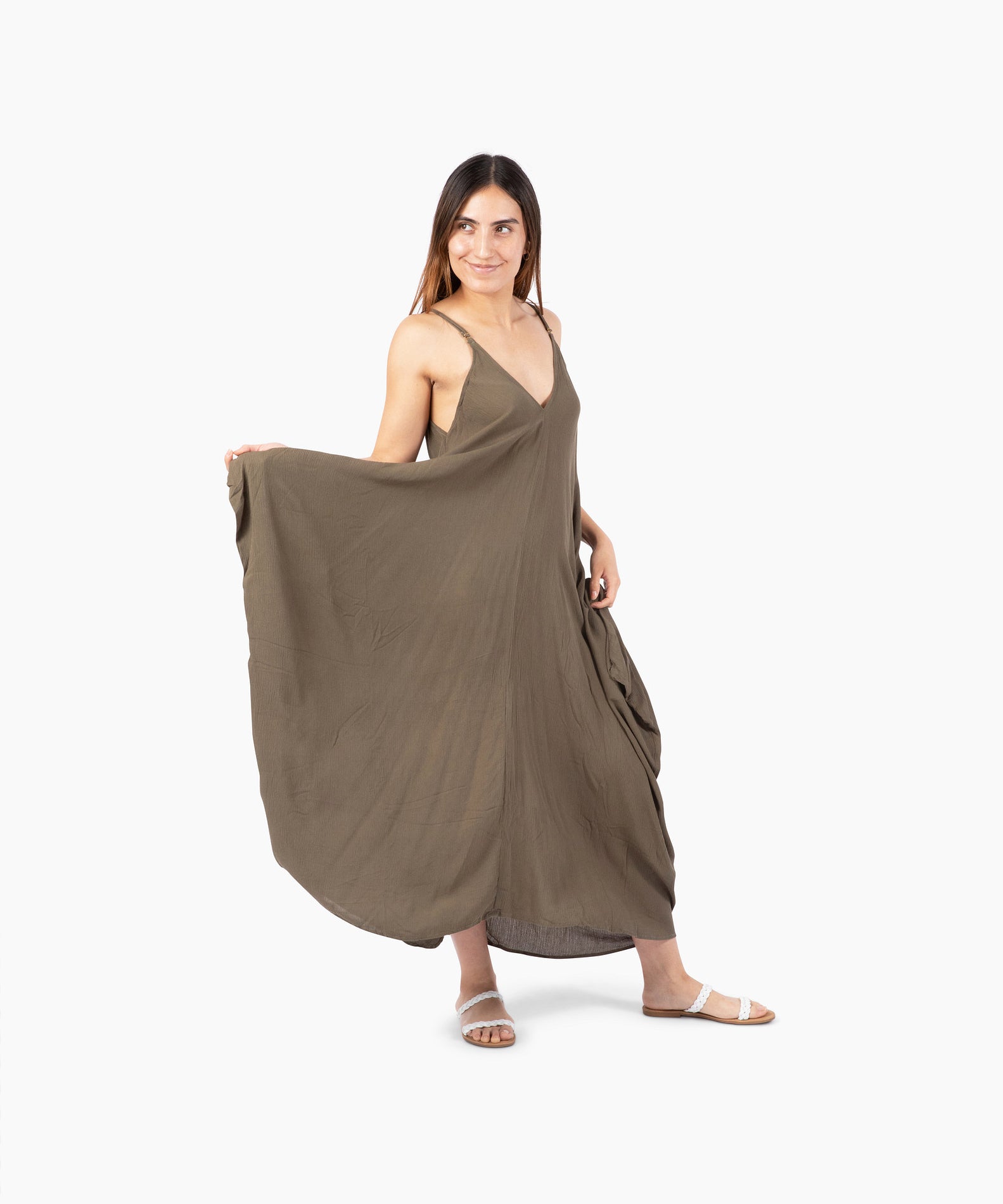 Woman wearing a flowing olive green dress on a white background #color_basil