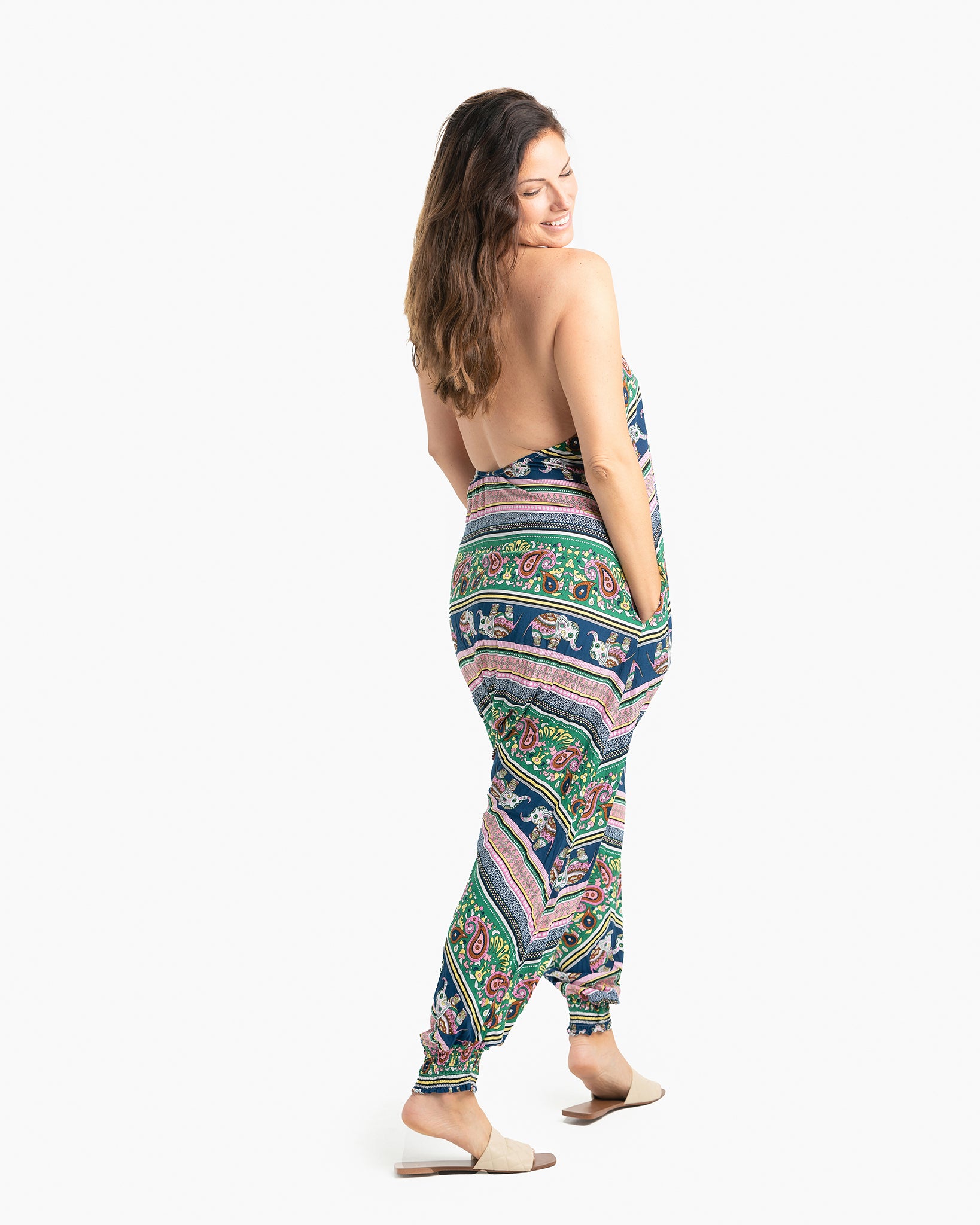 Side angle of woman wearing pink elephant print Savannah Flair jumpsuit #color_pink elephant