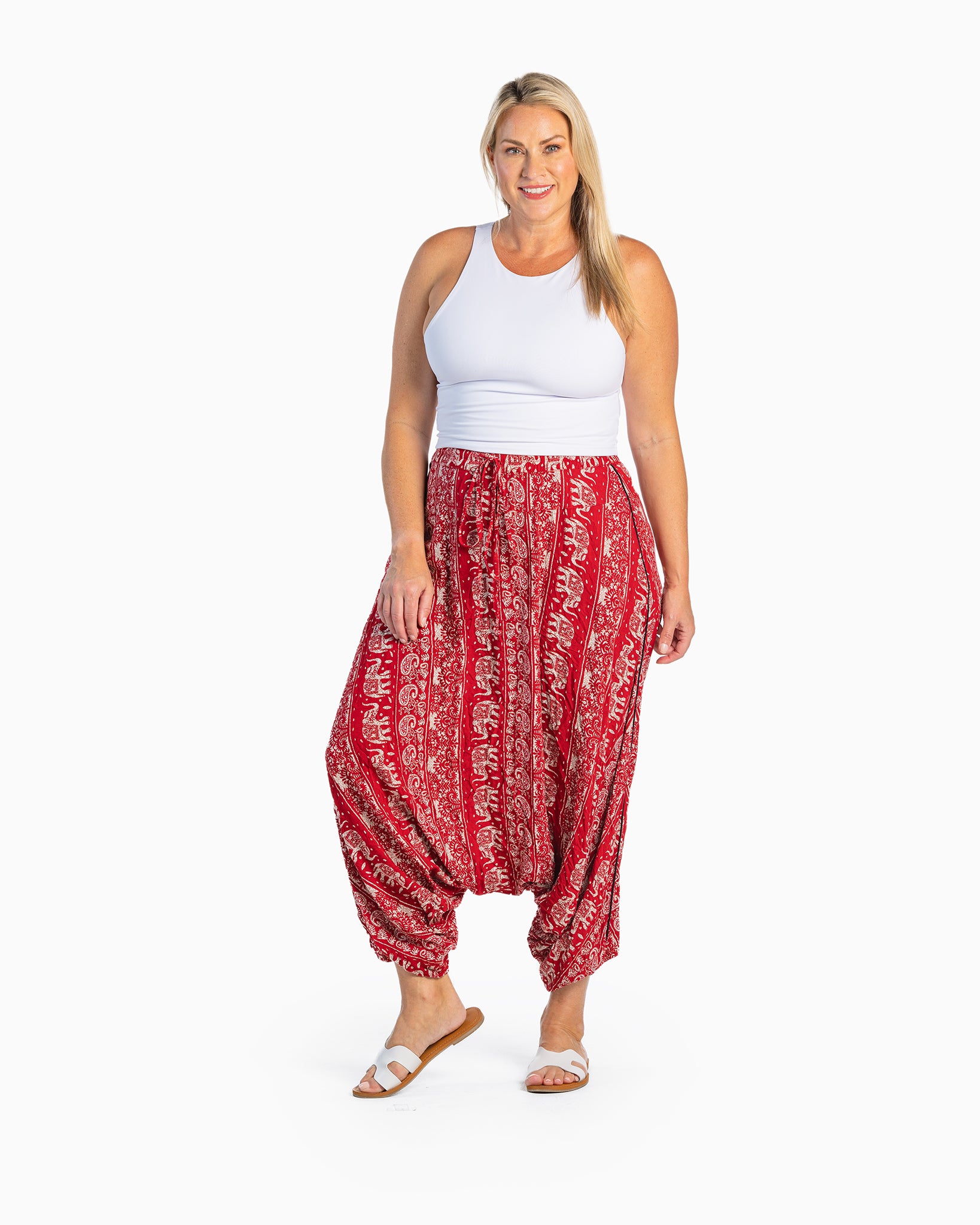 plus-size model posing in red lotus harem pants #color_red lotus